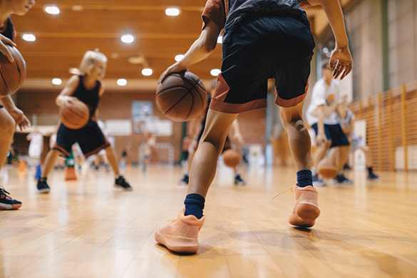 A youth basketball team practices on an indoor court