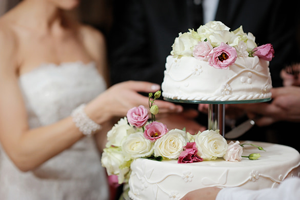 A bride and groom cut a cake on their wedding day