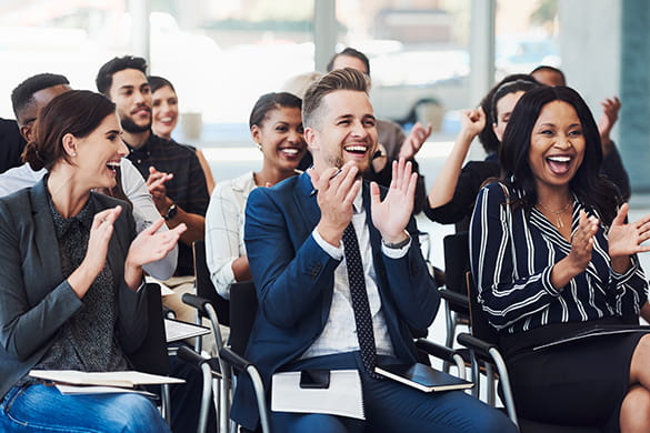 Conference attendees applaud after a presentation