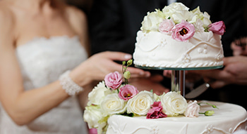 A bride and groom cut a cake on their wedding day