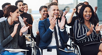 Conference attendees applaud after a presentation