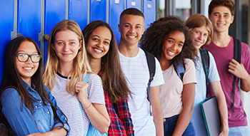 A lineup of students smiling with backpacks